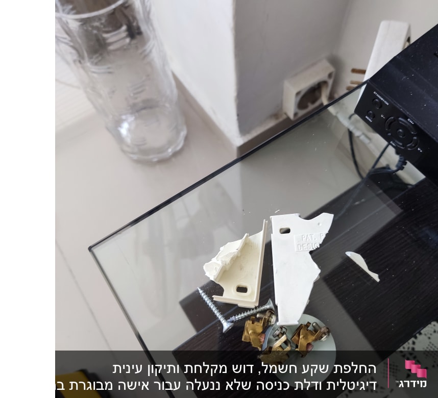 חלקי פלסטיק שבורים וברגים על שולחן זכוכית